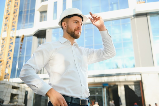 Architect in helmet near new building