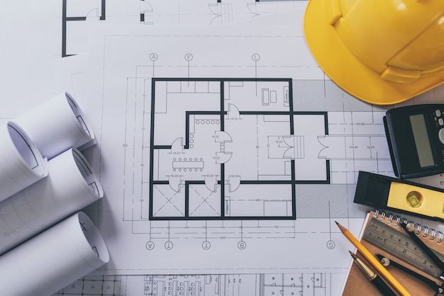 Architect house plan roled -up plans on the table, high angle view.