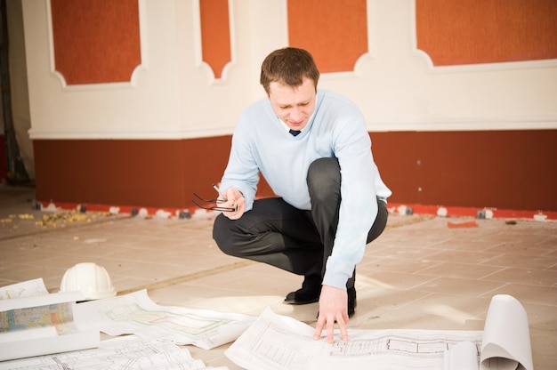 Photo architect looking blueprint on the floor. reconstruction interior.