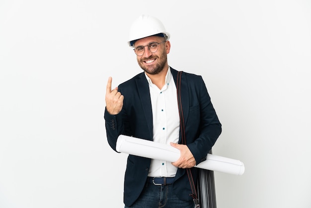 Architect man with helmet and holding blueprints isolated on white background doing coming gesture