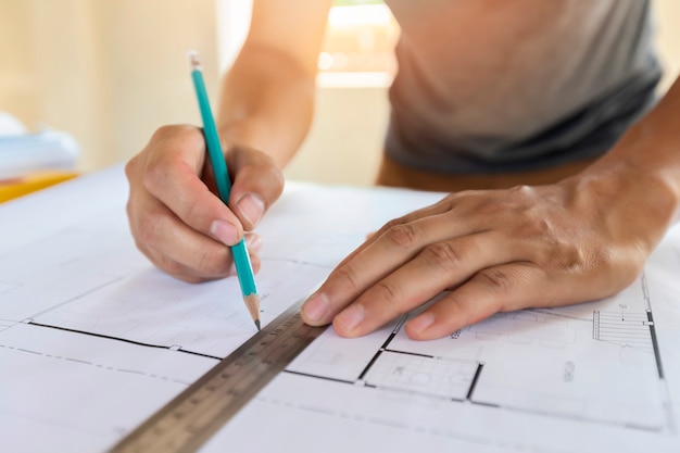 Architect measuring scale on blueprint in construction site