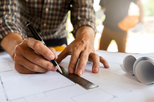 Architect measuring scale on blueprint in construction site