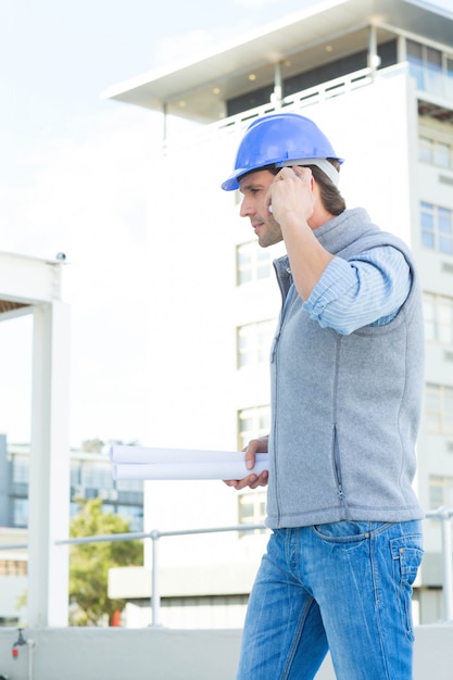 Architect met behulp van mobiele telefoon buiten gebouw