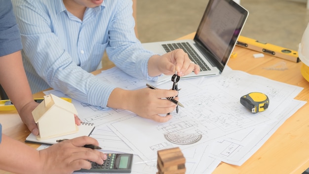 Architect or planner working on drawings for construction plans at a table