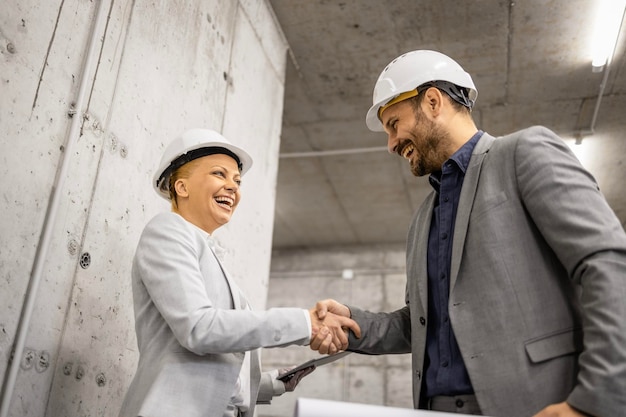 Architect shaking hands with construction engineer for successful cooperation