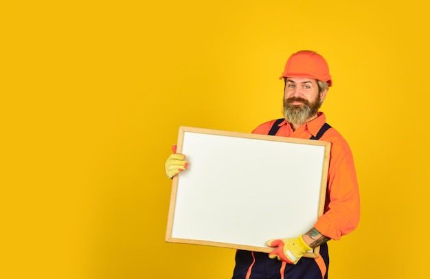 Architect showing project. Professional repairman. Troubleshoot concept. Repairman hold whiteboard copy space. Handsome repairman. Bearded man repairman builder. Plan repair works. Visual outline.