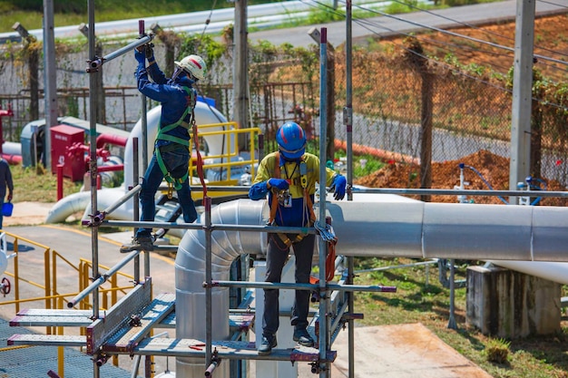 Architect on site construction workers on a scaffold pipeline Extensive scaffolding providing