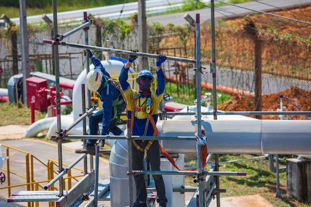 Architect on site construction workers on a scaffold pipeline