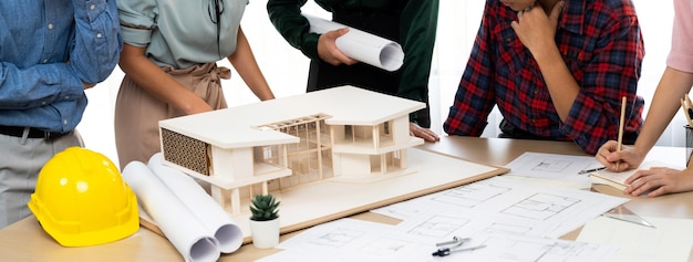 건축가 팀 분석 및 집 건설에 대한 브레인스토밍 회의 테이블에서 집 모델 블루프린트와 건축 장비가  ⁇ 어져 있습니다 창의적인 디자인과 팀워크