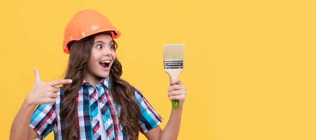 Architect teenager girl amazed teen girl pointing finger on painting brush child painter in helmet