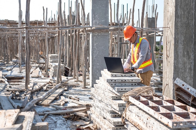 Architetto che per mezzo del computer portatile al cantiere