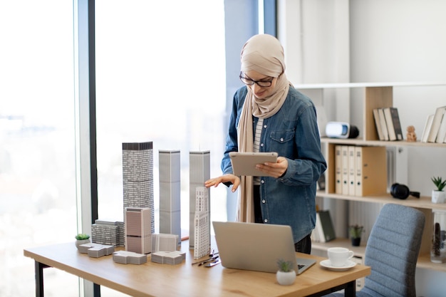 Architect using tablet for placing models on office desk