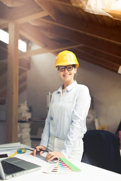 Architect wearing hardhat while working at construction site