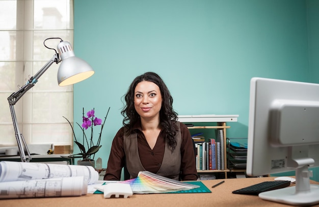 Architect with color palette on her desk. Working on new architect and design plan. Professional architecture blueprints