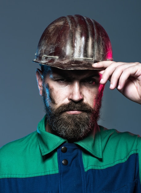 Architect, worker, engineer - work. Portrait architect builder on construction site. Builder in protective clothing and helmet. Male builder. Bearded construction worker in helmet. Hard work.