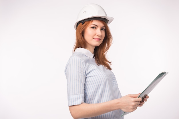 Architect, worker and realtor concept - woman builder or engineer in helmet with documents on white