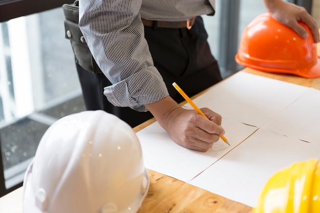 Architect working on blueprint of construction project in workplace