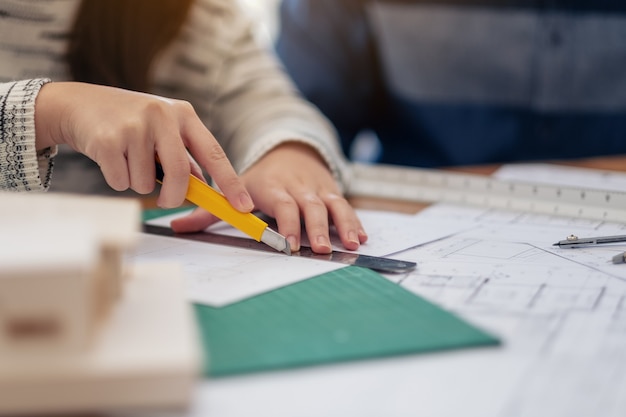 An architect working and cutting papers in office