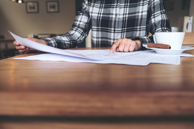 Photo an architect working and pointing at shop drawing paper on table