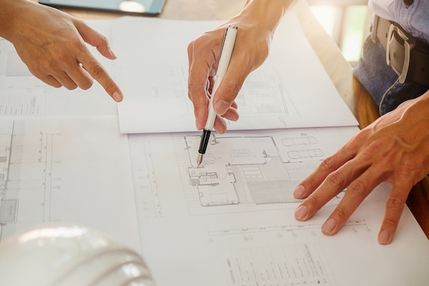 Architectenieur bespreken aan de tafel met blauwdruk