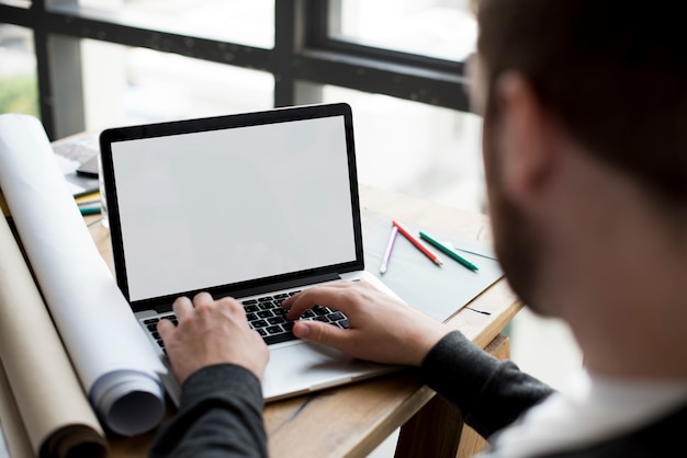 Architectenmens die gebruikend laptop werkt