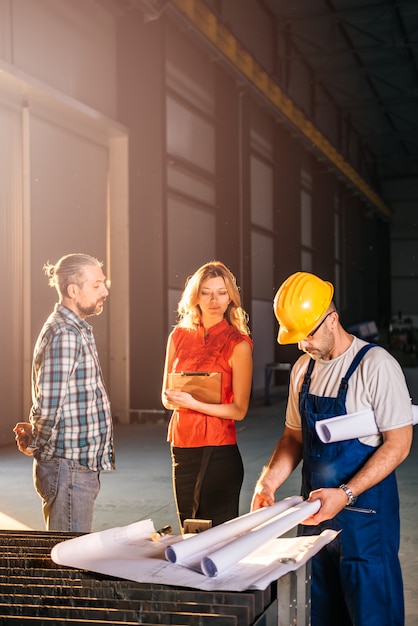 Architectenteam die blauwdruk controleren op het werkplaats