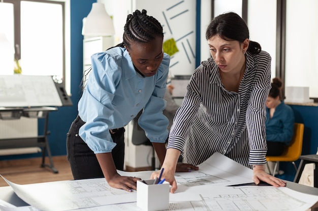 architectonisch team van multi-etnische vrouwen plannen schets blauwdruk lay-out voor ontwerp project gebouw