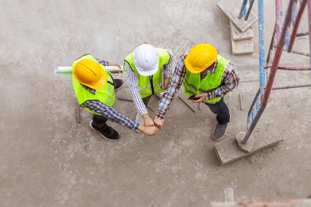 Architects construction engineers work together on the\
construction site joining forces for success