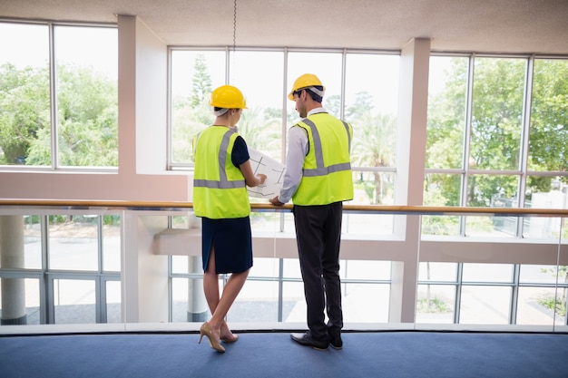 Architects discussing over blueprint