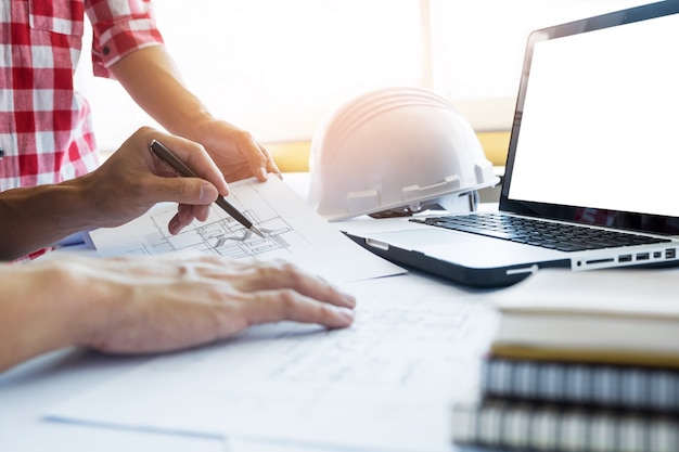 Architects engineer discussing at the table with blueprint - Closeup on hands and project print