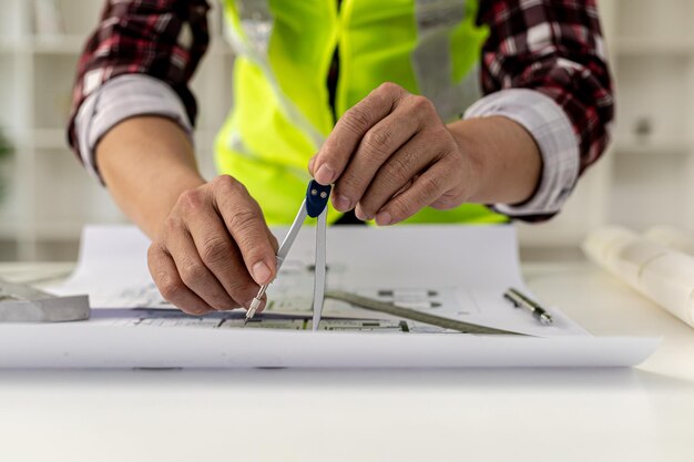 Architects, engineers, designers, use compasses to draw on\
house designs. he is editing the designs that have been created on\
the program on the computer. interior design and decoration\
ideas.