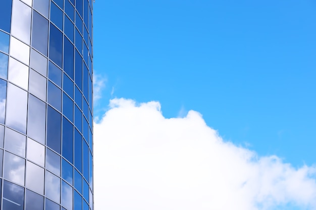 Architectural detail of the facade with multiple reflections of other buildings and the sun. Exterior of modern building. Architecture abstract background