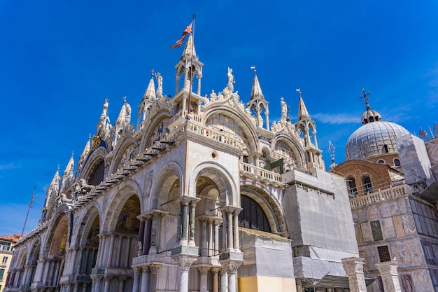 青い空の下、イタリア、ベニスのサンマルコのファサードの上部からの建築の詳細