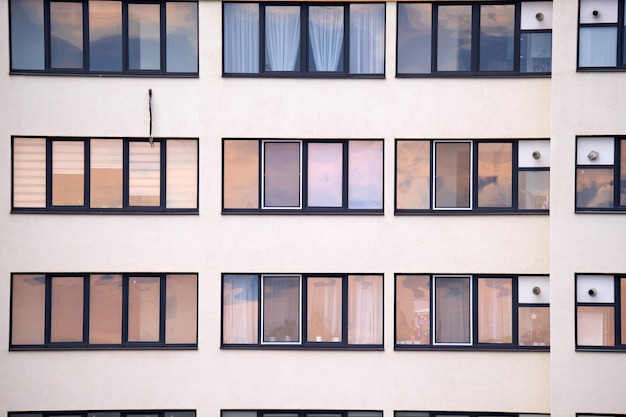 Architectural details of modern high apartment building facade with many windows and balconies