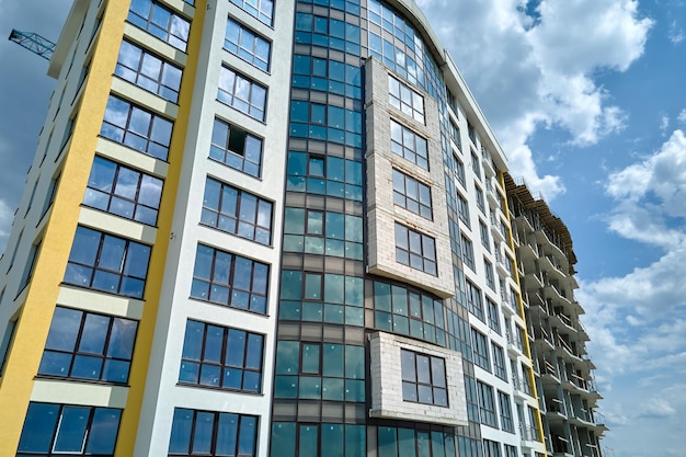 Architectural details of modern high apartment building facade with many windows and balconies