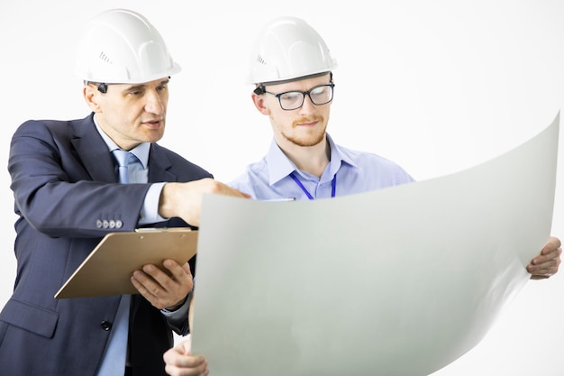 Architectural engineers work with blueprint documents reading instructions