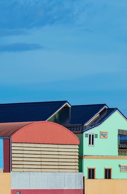 Architecture background of colorful house next to warehouse building against blue sky