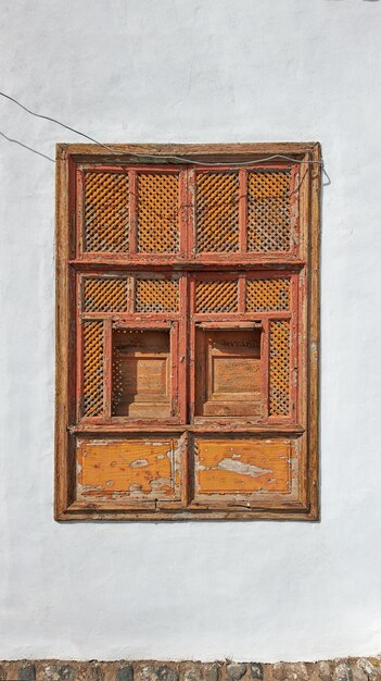 Architecture of an old grey wall with a rusted metal window outside Exterior texture details of an old rustic residential build with vintage wooden shut windows discovered in Santa Cruz de La Palma