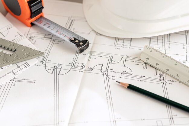 Architecture plans and contractor supplies on desk Close up Copy space