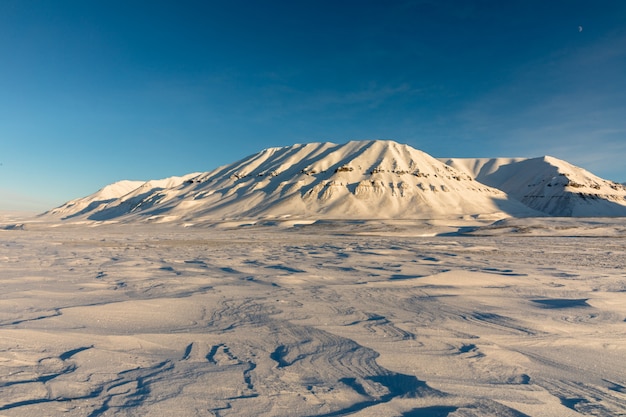 雪の北極の冬の風景は、ノルウェーのスバールバル諸島カプ・エクホルムの山々に覆われています