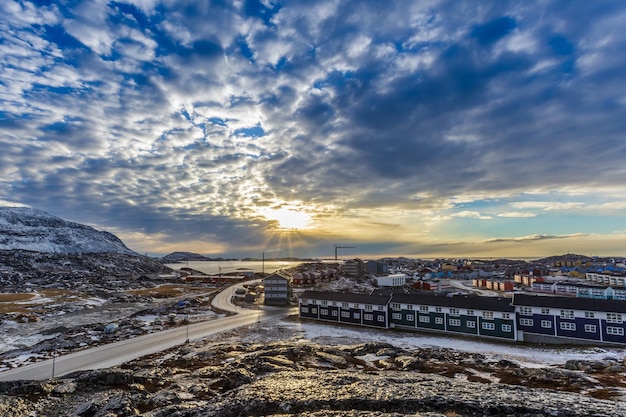 Arctische straten met huizen op de rotsachtige heuvels in het panorama van de zonsondergangstad Nuuk Groenland