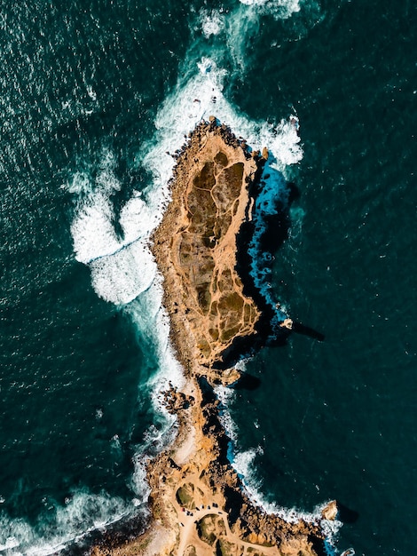 Areal view of atlantic ocean hitting the granite rocks on the coast rocky environment with amazing color of the ocean in Canary island Spain