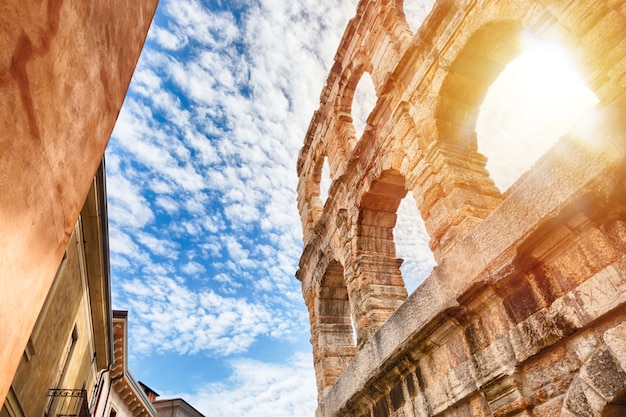 ヴェローナのアリーナ、日の出と雲と青い空の間にイタリアの古代ローマの円形劇場。