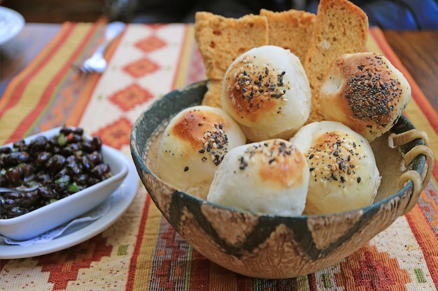 Argentijnse sesamtafelbroodjes en -broden in een houten mand met zwarte bonendip