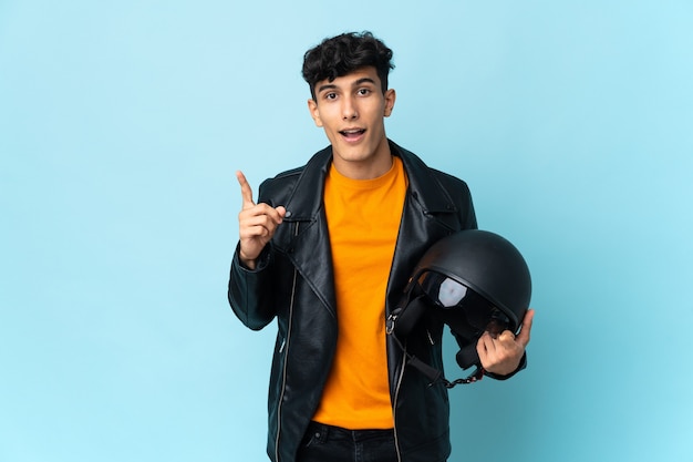 Argentinian man with a motorcycle helmet intending to realizes the solution while lifting a finger up