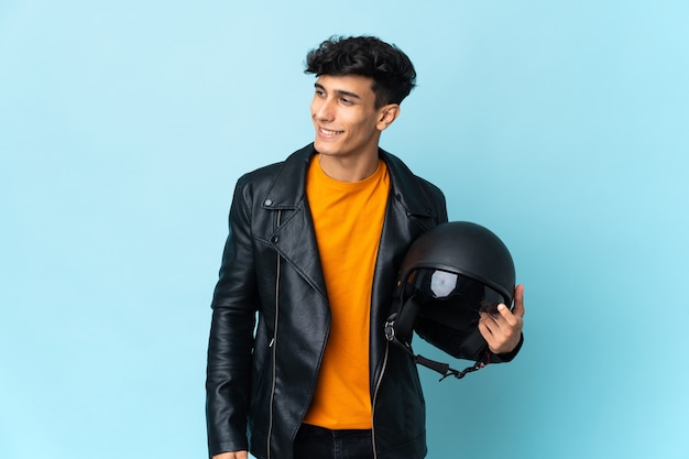 Argentinian man with a motorcycle helmet looking to the side and smiling