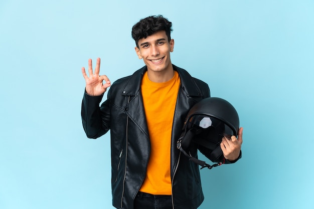 Argentinian man with a motorcycle helmet showing ok sign with fingers