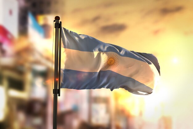 Argentinië vlag tegen stad wazige achtergrond bij zonsopgang achtergrondverlichting