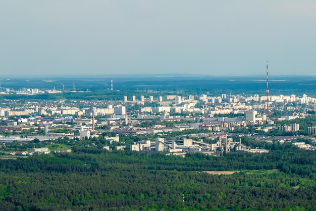 Ariel panoramic view of city and skyscrapers with a huge factory with smoking chimneys in the background