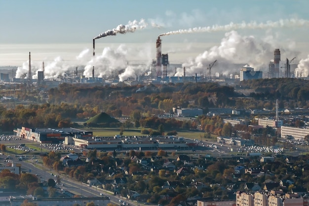 Ariel panoramisch uitzicht over de stad met enorme fabriek met rokende schoorstenen op de achtergrond